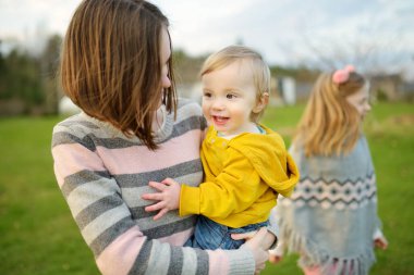 Şirin ablasının küçük kardeşiyle kucaklaşması. Sevimli genç kız kucağında erkek bebek. Geniş yaş farkı olan çocuklar. Kardeşler arasında büyük yaş farkı var. Büyük aile..