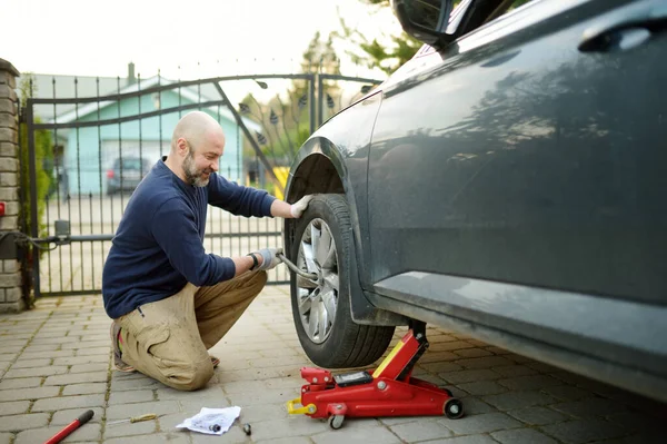 Young Man Changing Punctured Tyre His Car Loosening Nuts Wheel — Stock Photo, Image