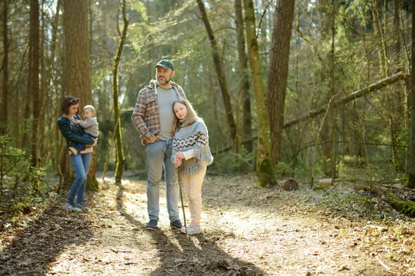 年轻的父亲和他的三个孩子在森林里远足 在阳光明媚的春天 一家四口在一条小径上玩得开心 与儿童一起探索自然 — 图库照片