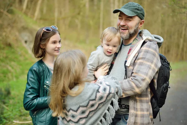 年轻的父亲和他的三个孩子在森林里远足 在阳光明媚的春天 一家四口在一条小径上玩得开心 与儿童一起探索自然 — 图库照片