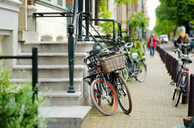 Birçok bisiklet Amsterdam, Hollanda caddesinde park edildi. Hollanda 'da tipik Hollanda şehir manzarası.