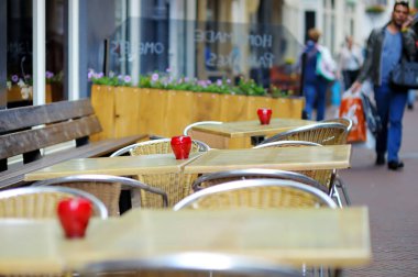 AMSTERDAM - 2011: Hollanda, Hollanda 'da tipik bir Amsterdam caddesinde kırmızı mumlarla süslenmiş boş restoran masası