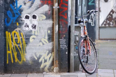 AMSTERDAM - 2011: Üzerinde Hollandalı ünlü çocuk kitabı karakterleri Amsterdam, Hollanda 'nın ünlü çocuk kitabı Jip ve Janneke' nin resmi olan boyalı bir duvarın yanına park edilmiş bisiklet.