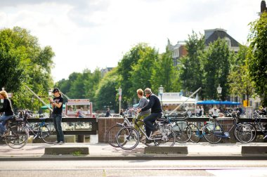 AMSTERDAM - AĞUSTUSTUSTOS 2011: Amsterdam, Hollanda 'da her gün turistlerin ve kasaba halkının yoğun hayatı. Amsterdam, Hollanda 'da tipik sokak manzarası.