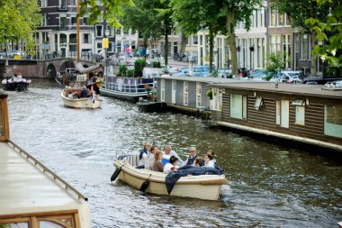 AMSTERDAM - AĞUSTUSTOS 2011: Hollanda 'nın ünlü kanalları. Arabalar ve bisikletler setin üzerine park edilmiş. Amsterdam, Hollanda 'da tipik sokak manzarası.