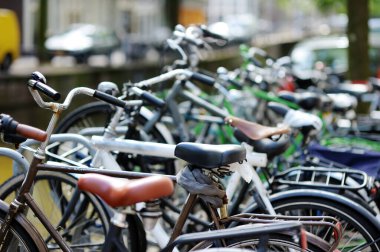Birçok bisiklet Amsterdam, Hollanda caddesinde park edildi. Hollanda 'da tipik Hollanda şehir manzarası.