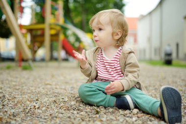 Küçük tatlı çocuk sıcak bir yaz gününde dışarıda oyun parkında eğleniyor. Yazın çocuklar için aktif eğlence.