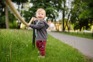 Komik çocuk güneşli yaz gününde dışarıda eğleniyor. Doğayı keşfeden çocuk. Küçük çocuklar için yaz etkinlikleri.