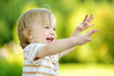 Komik çocuk güneşli yaz gününde dışarıda eğleniyor. Doğayı keşfeden çocuk. Küçük çocuklar için yaz etkinlikleri.