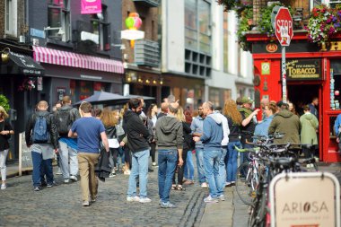 DUBLIN, İrlanda - Mayıs 2018 Dublin, İrlanda 'da her gün turistlerin ve kasaba halkının yoğun hayatı. Güneşli bir günde ünlü Temple Bar 'ın önünden geçenler.