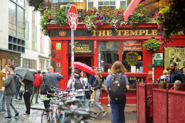 DUBLIN, İrlanda - Mayıs 2018 Dublin, İrlanda 'da her gün turistlerin ve kasaba halkının yoğun hayatı. Yağmurlu bir günde ünlü Temple Bar 'ın önünden geçenler.