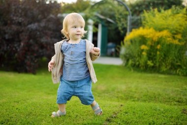 Komik çocuk güneşli yaz gününde dışarıda eğleniyor. Doğayı keşfeden çocuk. Küçük çocuklar için yaz etkinlikleri.