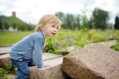 Komik çocuk güneşli yaz gününde dışarıda eğleniyor. Doğayı keşfeden çocuk. Küçük çocuklar için yaz etkinlikleri.