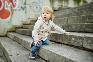 Komik çocuk güneşli bir sonbahar gününde dışarıda eğleniyor. Doğayı keşfeden çocuk. Şehir parkında yürüyen bir çocuk. Küçük çocuklar için sonbahar aktiviteleri.