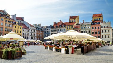 VARŞAN, POLAND - Ağustos 2021: Turistler, İkinci Dünya Savaşı sırasında tamamen yok olan ve daha sonra savaş öncesi görünümüne geri dönen güzel Eski Kent Pazar Meydanı 'nı keşfettiler.