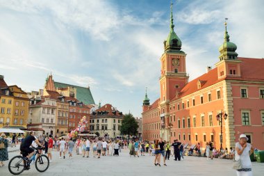 WARsaw, POLAND - Ağustos 2021: Turistler İkinci Dünya Savaşı sırasında tamamen yıkılan ve 1949-1953 yılları arasında yeniden inşa edilen Eski Şehrin güzel sokaklarını keşfediyorlar. Güneşli yaz günü.