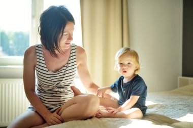 Annesinin kollarında sevimli, komik bir çocuk. Anne ve oğlu güneşli bir yaz gününde evde eğleniyorlar. Sevimli oğlu annesi tarafından tutuluyor..