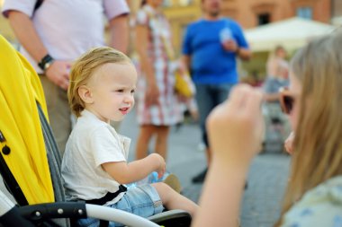 Tatlı çocuk ve ablası Varşova 'nın eski kasabasının güzel sokaklarını keşfediyorlar. Genç bir kız ve erkek kardeşi açık havada bebek arabasında. Aile yazın yürür..