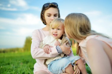 İki kız kardeş ve yeni yürümeye başlayan erkek kardeşleri güneşli bir yaz gününde dışarıda eğleniyorlar. Doğayı keşfeden çocuklar. Yazın veya ilkbaharda yüksek dağlar ve yeşil tepeler. Polonya 'da manzara dağ manzarası.