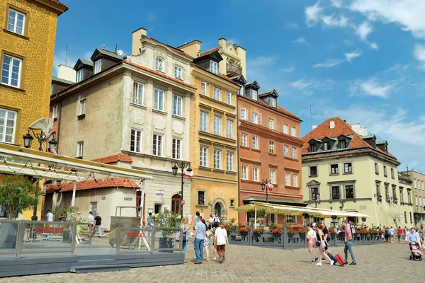 WARsaw, POLAND - Ağustos 2021: Turistler İkinci Dünya Savaşı sırasında tamamen yıkılan ve 1949-1953 yılları arasında yeniden inşa edilen Eski Şehrin güzel sokaklarını keşfediyorlar. Güneşli yaz günü.