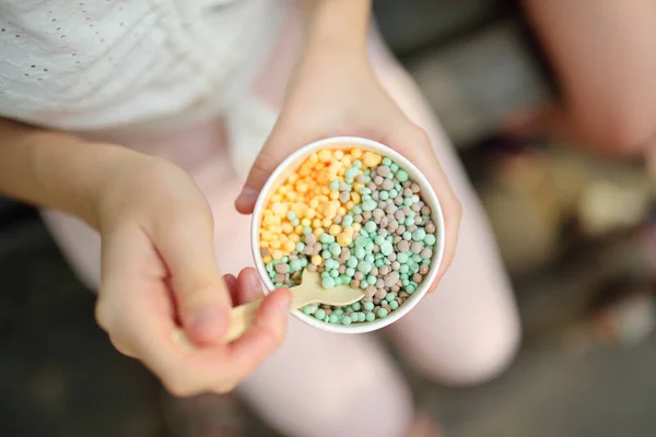 Eating tasty drops ice cream outdoors on hot summer day. Sweets for kids.