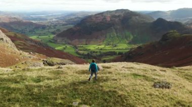 Aerial footage of female tourist enjoying view of Great Langdale valley in the Lake District, famous for its glacial ribbon lakes and rugged mountains, Cumbria, North West England.