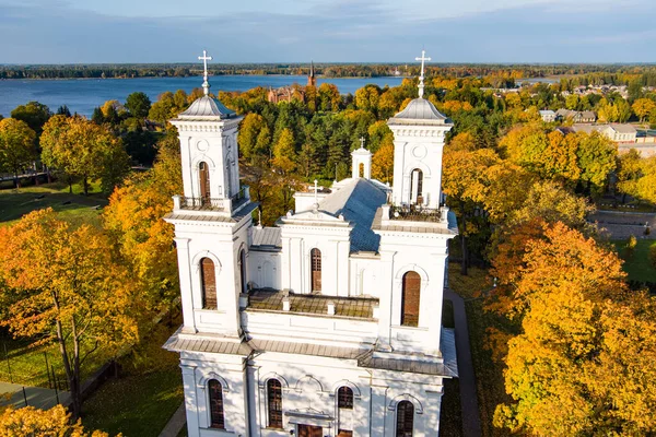 Beautiful aerial view of St. John the Baptist\'s Church in Birzai surrounded by autumn vegetation on sunny fall day. Birzai, Lithuania.