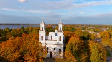 Beautiful aerial view of St. John the Baptists Church in Birzai surrounded by autumn vegetation on sunny fall day. Birzai, Lithuania.