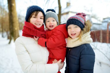 İki abla ve küçük erkek kardeşleri dışarıda eğleniyorlar. İki genç kız, kış günü erkek kardeşlerini kucağında tutuyorlar. Kış tatilinde çocuklar. Çocuklar birlikte doğayı keşfediyorlar..