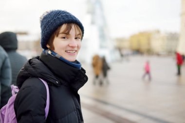 Soğuk kış sabahında sırt çantalı tatlı bir kız okula gidiyor. Çocuk okula geri dönüyor. Çocuklar için eğitim.