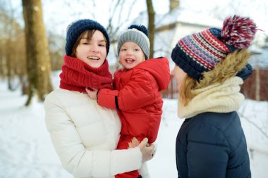 İki abla ve küçük erkek kardeşleri dışarıda eğleniyorlar. İki genç kız, kış günü erkek kardeşlerini kucağında tutuyorlar. Kış tatilinde çocuklar. Çocuklar birlikte doğayı keşfediyorlar..