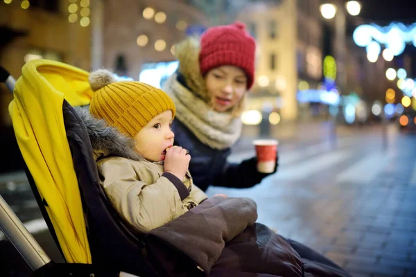 在立陶宛维尔纽斯 可爱的幼儿男孩和他的姐姐在圣诞节玩得很开心 在圣诞市场上的婴儿车里 与家人和孩子共度冬季 — 图库照片