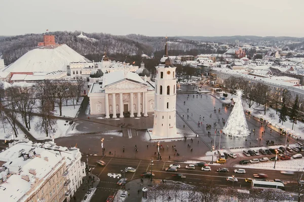 Aerial Vilnius city panorama in winter with snow covered houses, churches and streets. Cathedral square and Christmas tree. Winter city scenery in Vilnius, Lithuania.