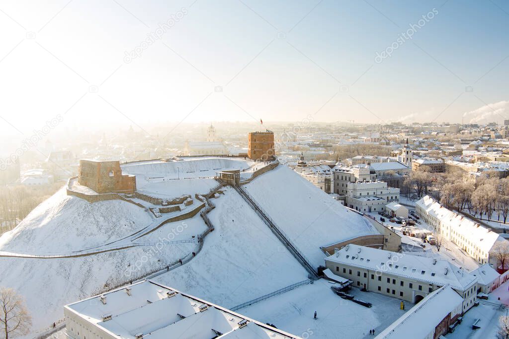 Aerial Vilnius city panorama in winter with snow covered houses, churches and streets. Gediminas tower in evening light. Winter city scenery in Vilnius, Lithuania.