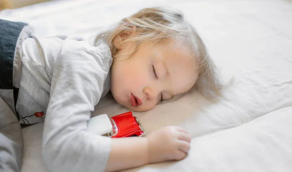 Förtjusande Liten Pojke Sover Sängen Med Sin Leksaksbil Trött Barn — Stockfoto