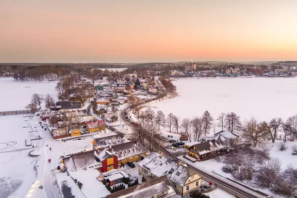 Aerial view of Trakai town, known for Trakai Island Castle. Snow covered frozen Galve lake on sunny winter sunrise. Scenic winter scenery near Vilnius, Lithuania.