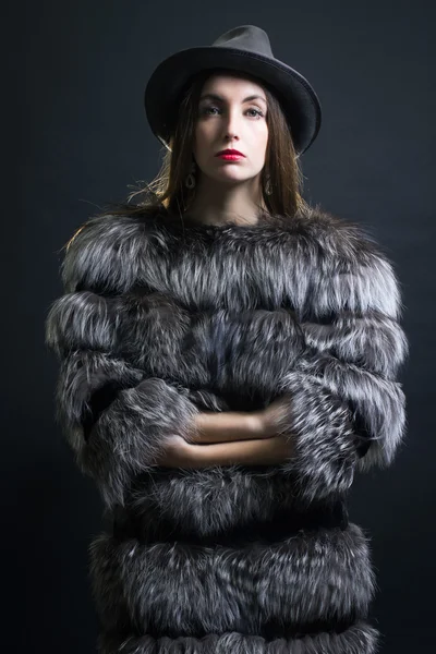Genç kadın bir kürk manto ve şapka. — Stok fotoğraf