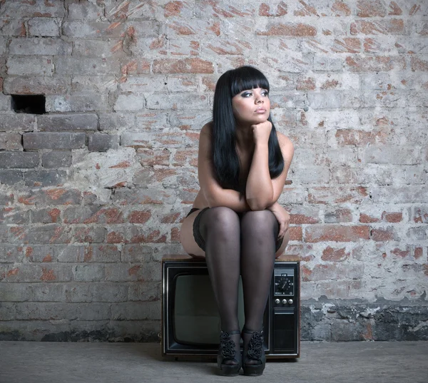 Sexy woman sitting on retro TV. — Stock Photo, Image