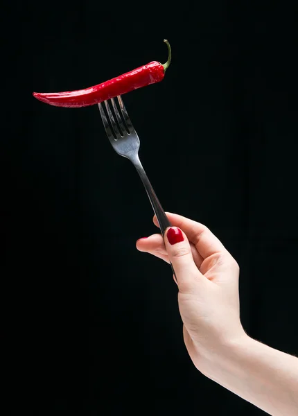 Hot pepper on the fork in the female hand. — Stock Photo, Image