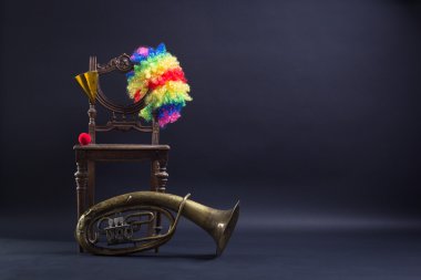 giyim palyaço ve retro bir sandalyede trombon.