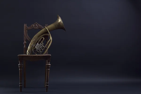 Antika ahşap sandalye ve trompet siyah zemin. — Stok fotoğraf