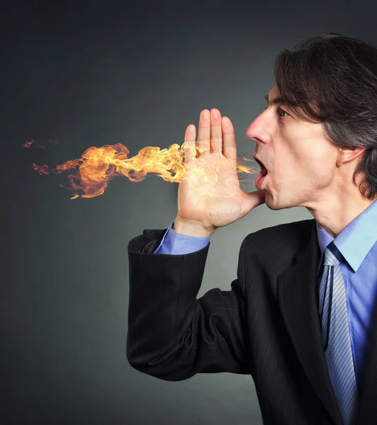 From the mouth of a man a fire erupts. Men suffering from heartburn. — Stock Photo, Image