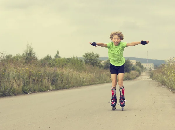 Boy riding on rollers on the road — Stock Photo, Image