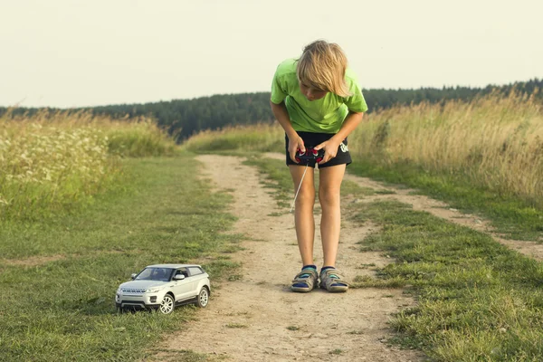 Criança brincando com um carro de brinquedo controlado remotamente — Fotografia de Stock