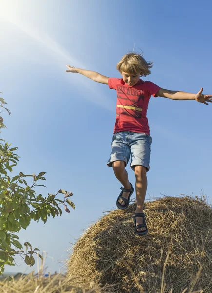 Chłopiec skacze z hayrick — Zdjęcie stockowe
