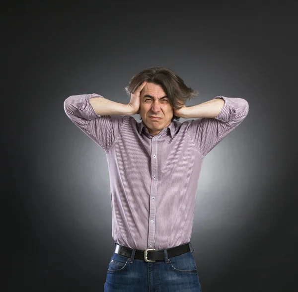 Man bedekt zijn oren met zijn handen — Stockfoto