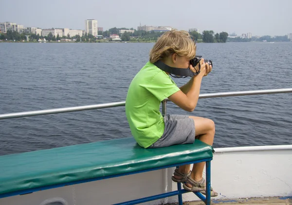 Chico fotografiando en el barco — Stockfoto