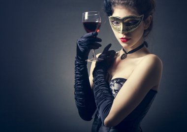 bir kadeh şarap ile karnaval maskesi kadında.