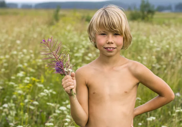 Kisfiú egy csokor vadvirággal. — Stock Fotó