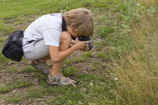 Menino fazendo fotografias de flores — Fotografia de Stock